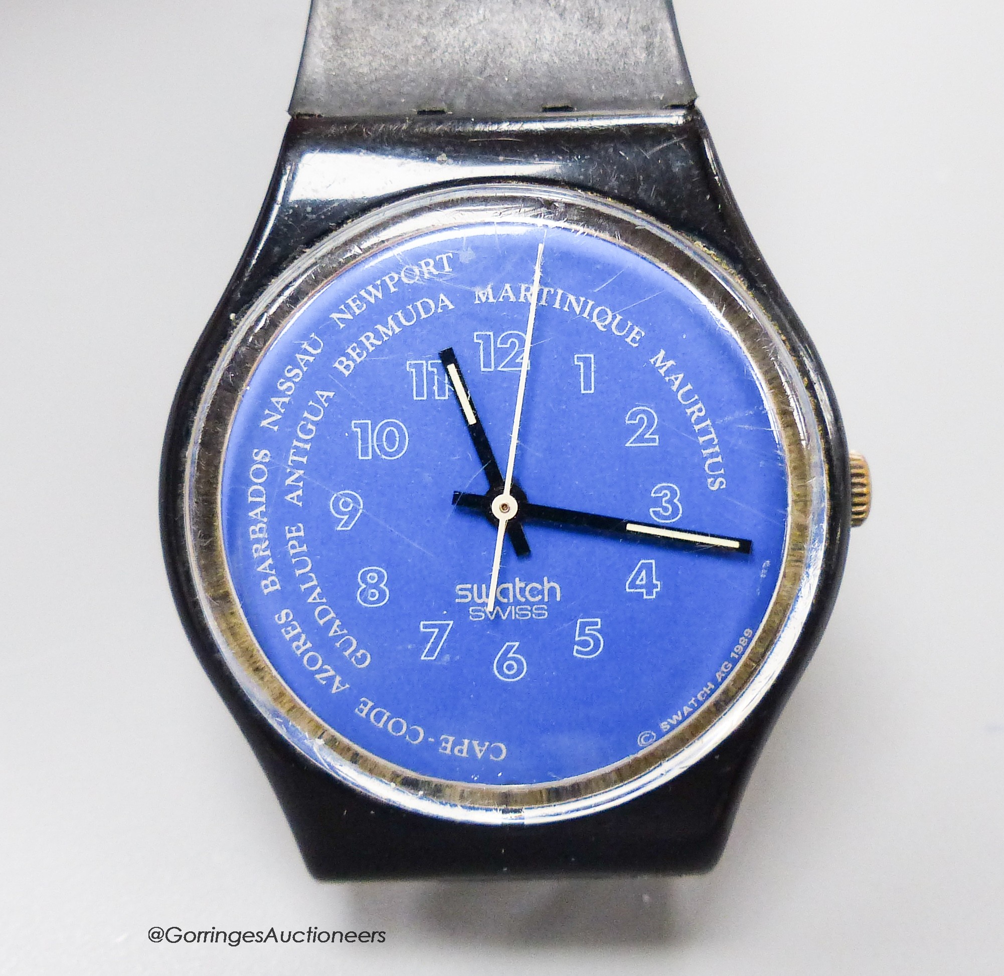 A Swatch watch (strap a.f.).